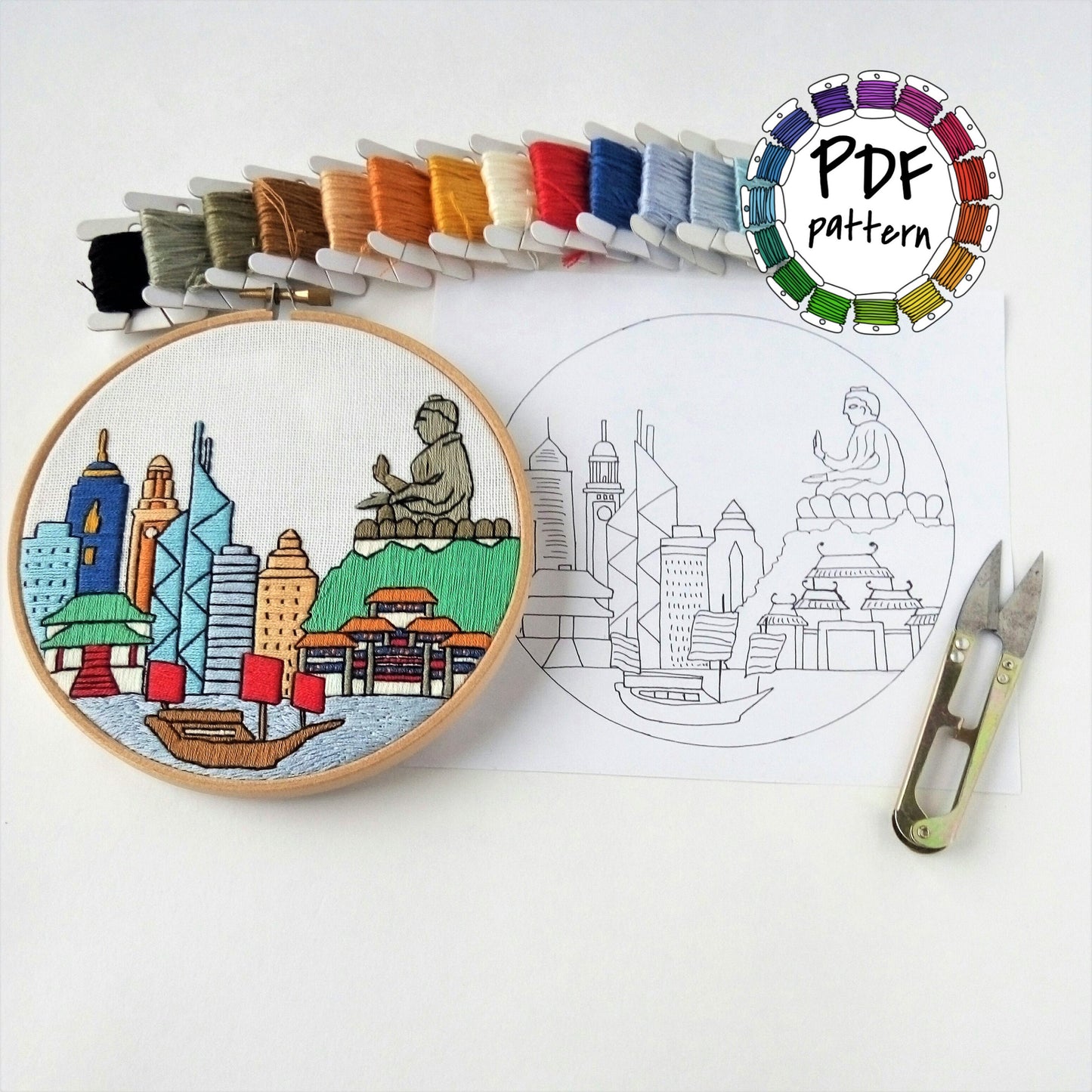 Hong Kong cityscape hand embroidery pattern with colorful threads and scissors on white background