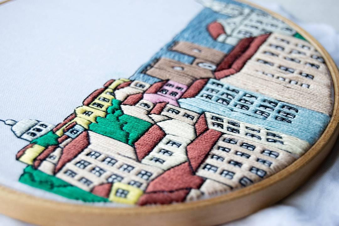 Embroidery hoop with a colorful cityscape design on fabric