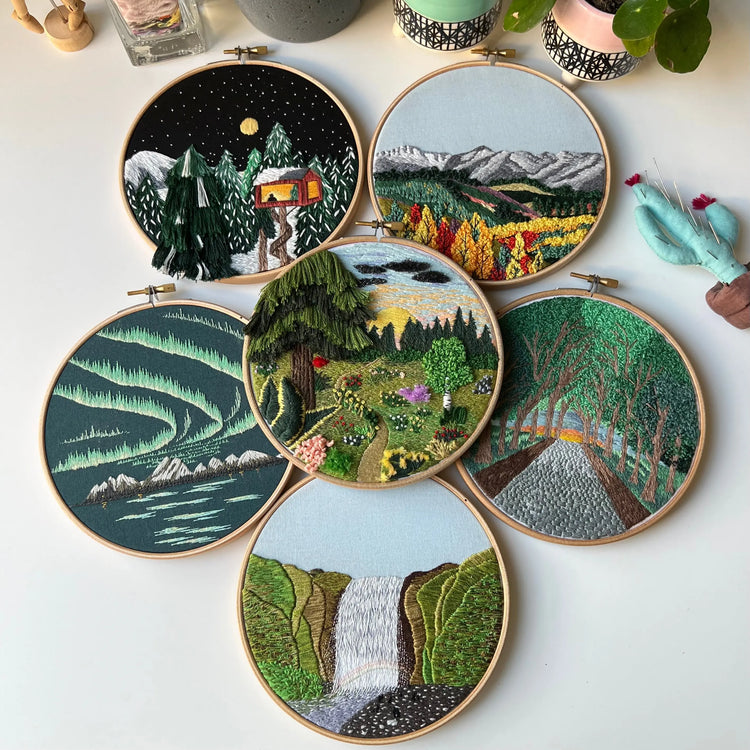 Collection of embroidery pattern bundles featuring multiple landscape designs in wooden hoops
