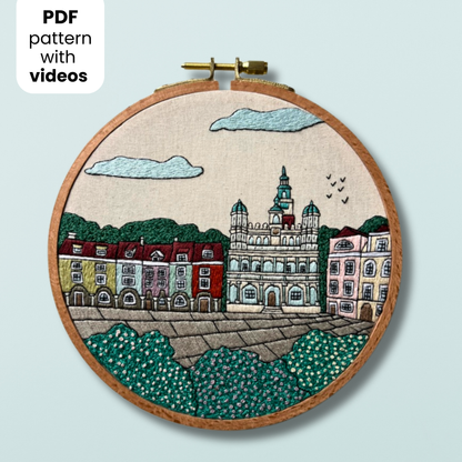Embroidery hoop with a cityscape Poznan design on a light blue background