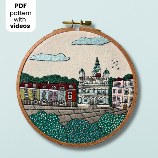 Embroidery hoop with a cityscape Poznan design on a light blue background