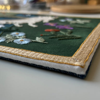 Embroidered fabric with floral patterns on a green background
