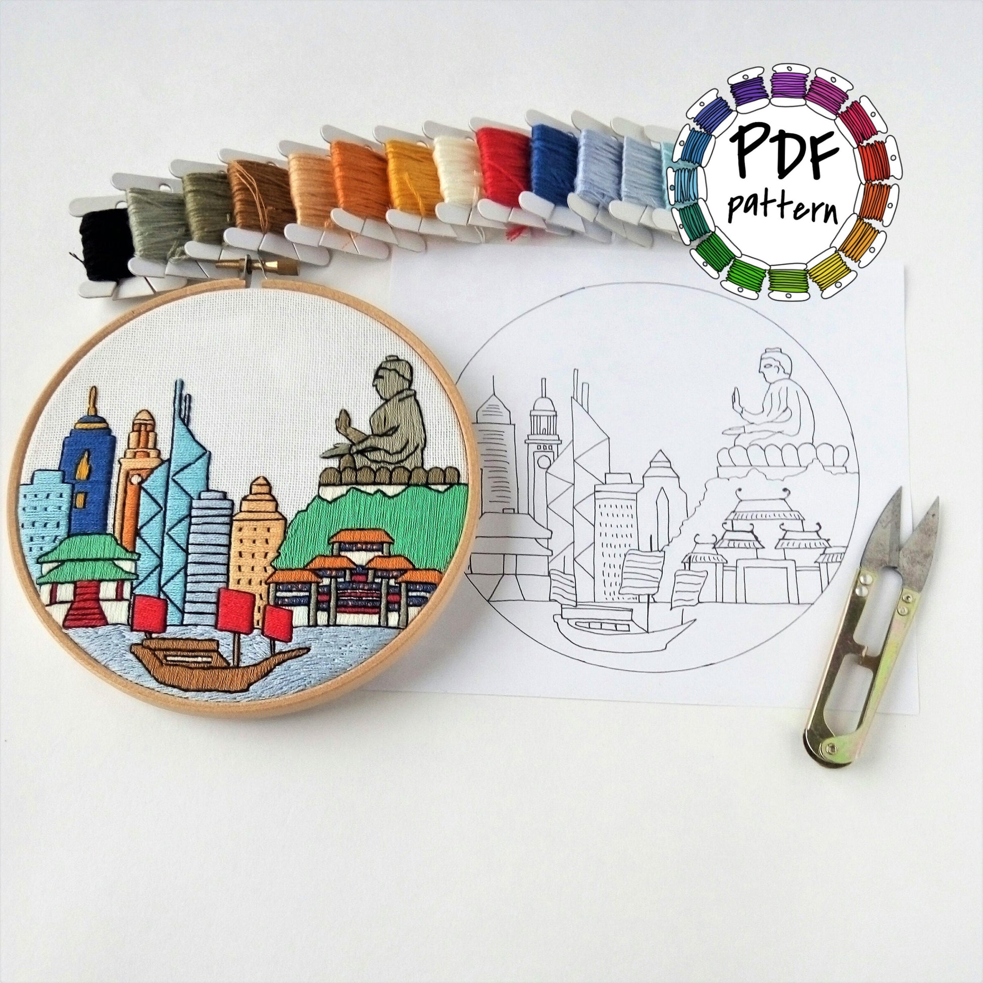 Hong Kong cityscape hand embroidery pattern with colorful threads and scissors on white background