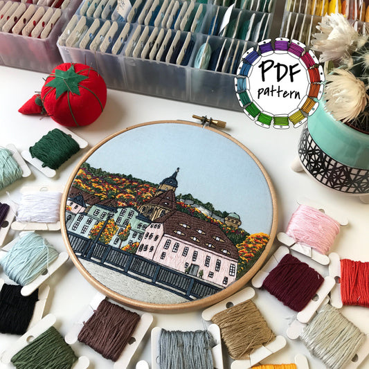Hand embroidery pattern of Königstein forest and fortress with colorful threads and hoop.